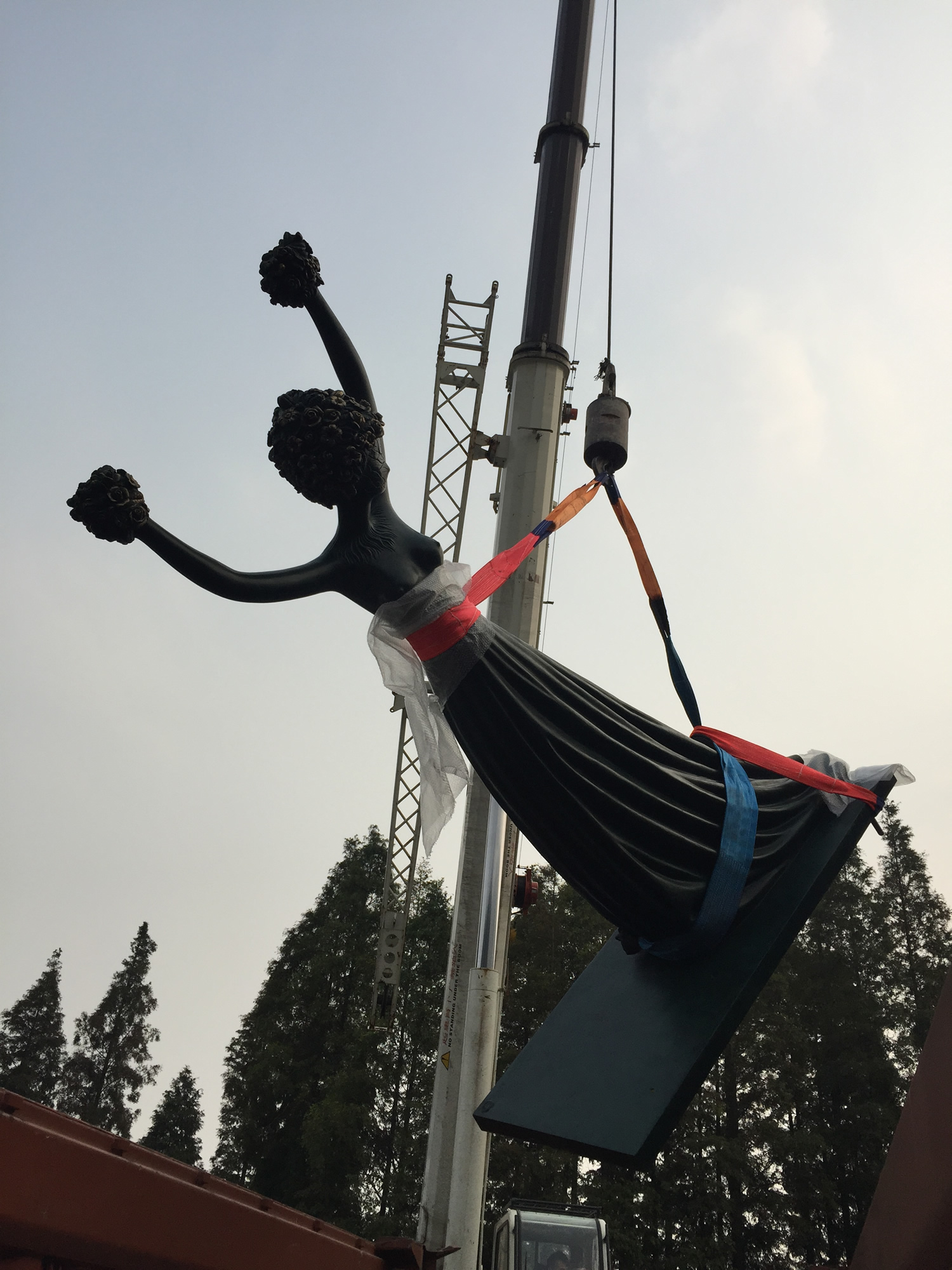 A sculpture lifted by crane